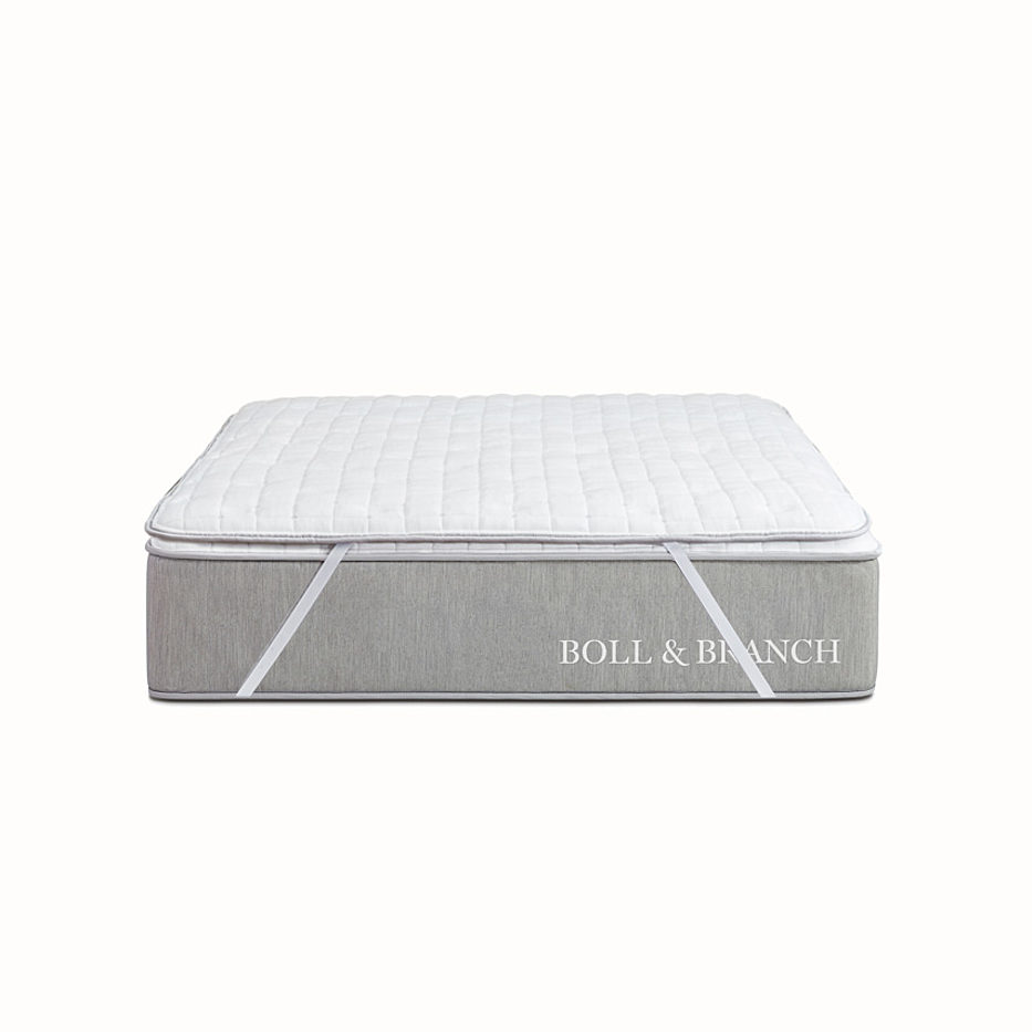White wool mattress topper secured to a mattress from Boll & Branch