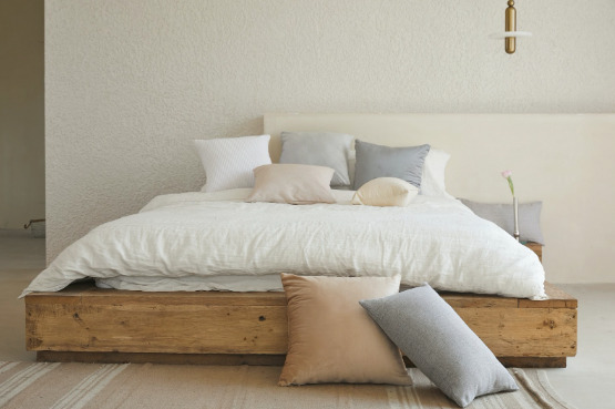 Organic bedding on a wooden bed frame consisting of beautiful, natural and chemical free pillows.