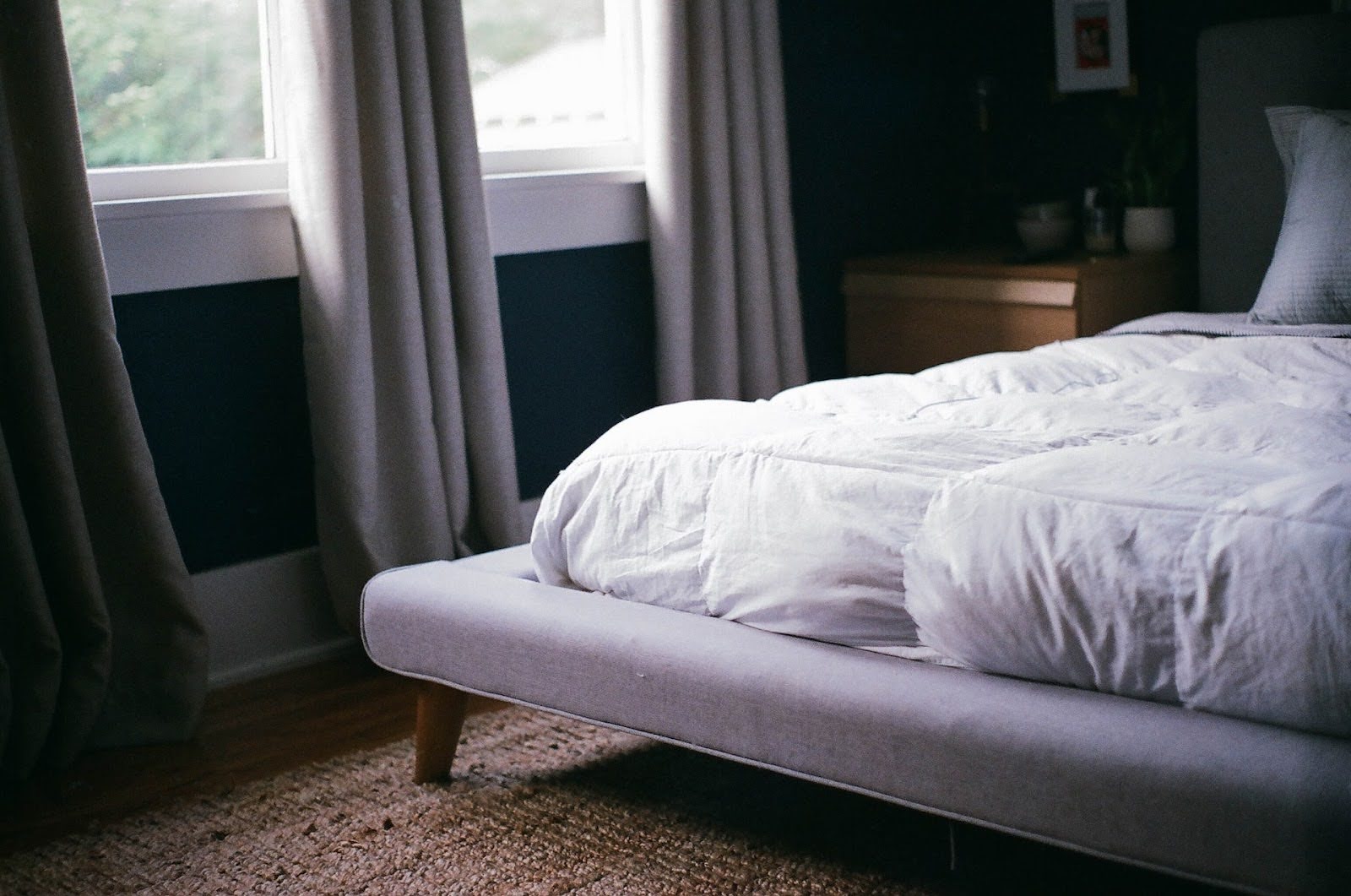 A bed sits in a room with an organic mattress topper