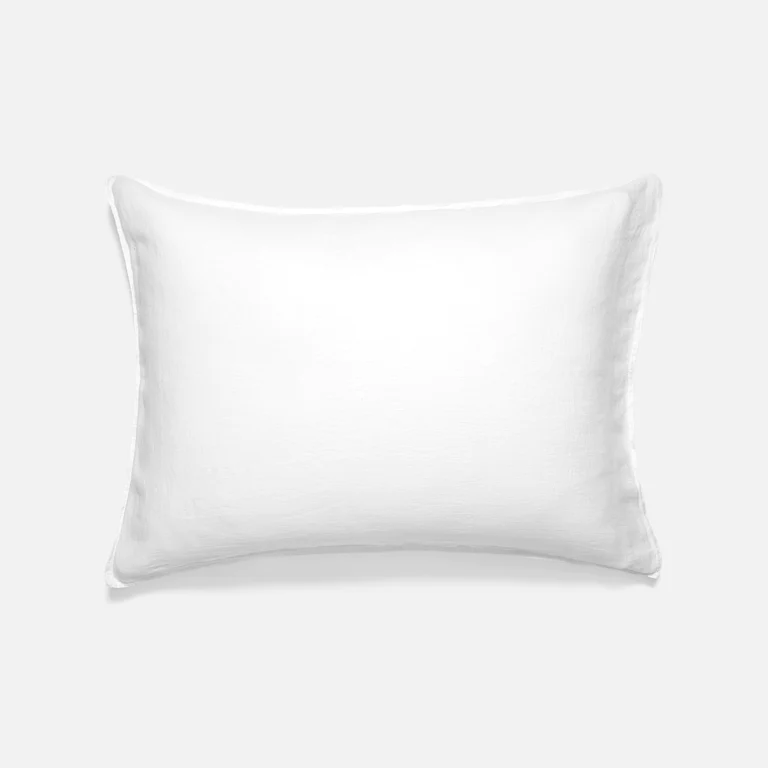 A single pillow covered in a white Brooklinen flax pillowcase