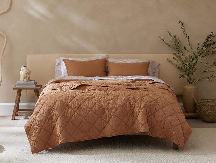 The Coyuchi Diamond-Stitched Organic Cotton Comforter on a bed