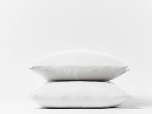 Two pillows covered in white Coyuchi organic cotton jersey pillowcases