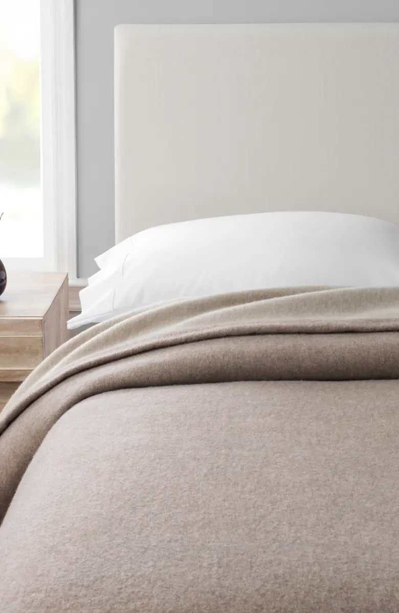 A Melange Home merino wool blanket on a bed