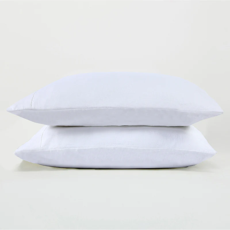 Two pillows covered in white Sijo LuxeWeave organic linen pillowcases