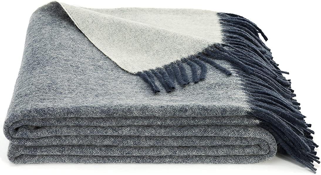 A folded blue Spencer & Whitney merino wool blanket