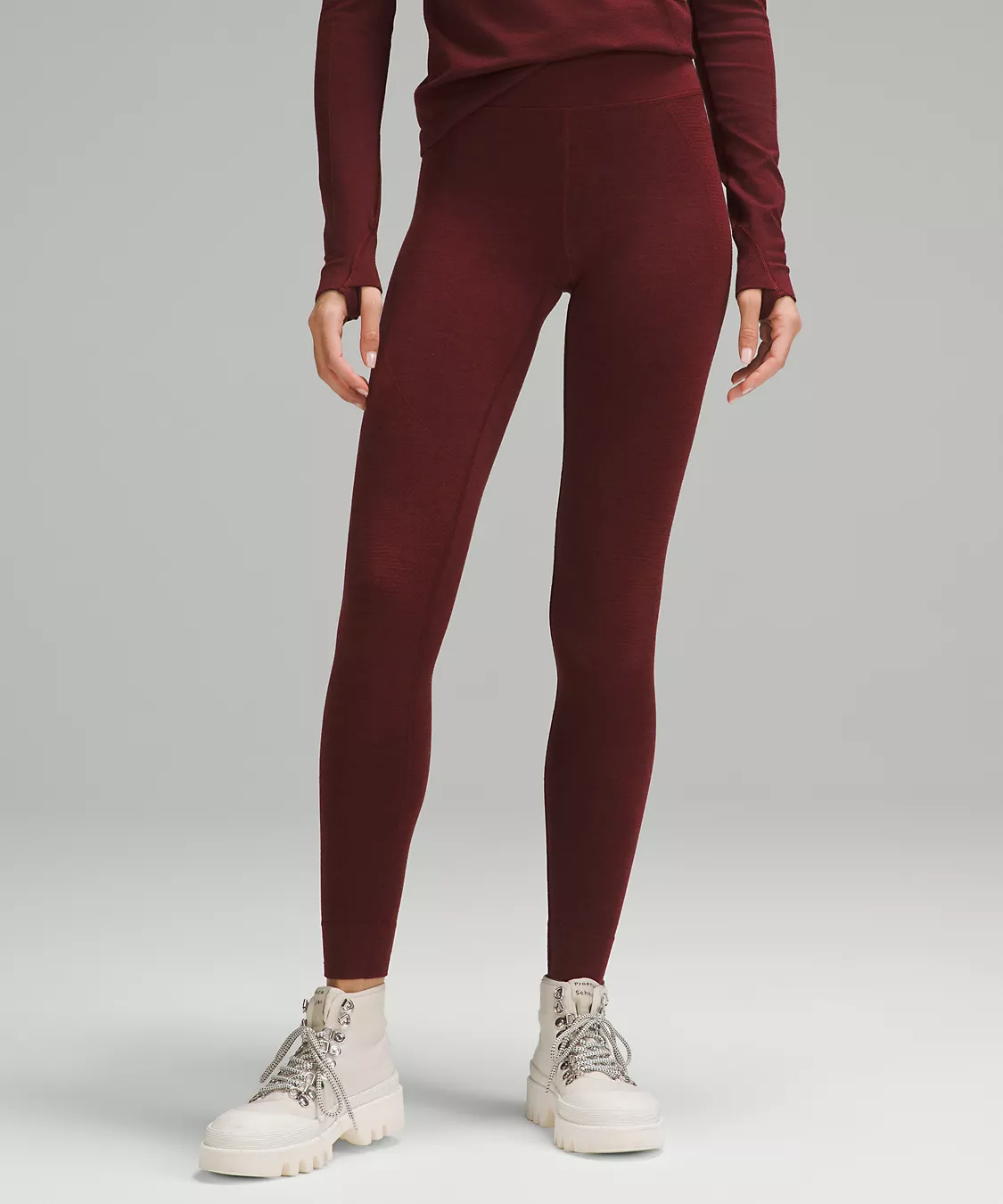 woman wearing merlot-colored wool leggings from lululemon with ivory hiking books