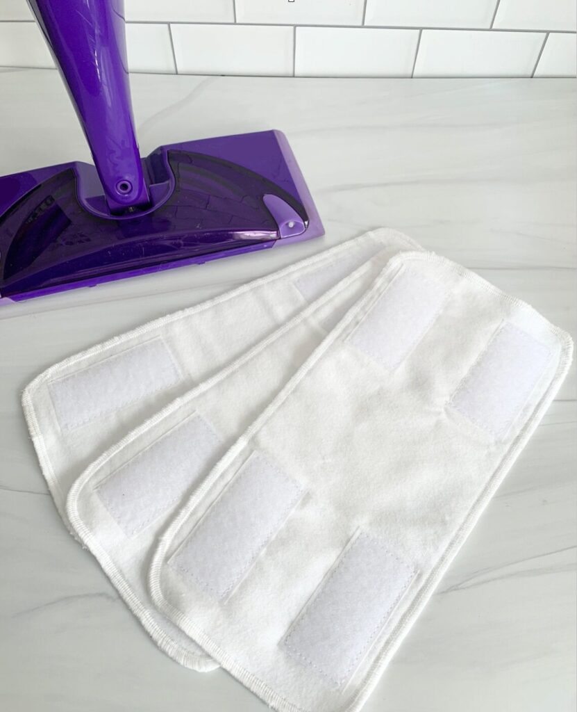 Washable mop covers made of reusable cotton, shown next to a Swiffer Wet Jet.