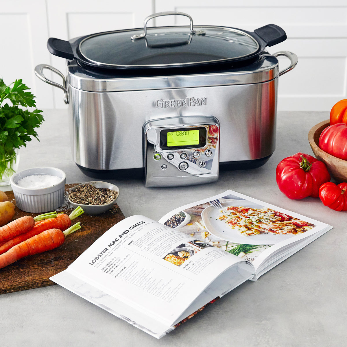 Prepare Healthy Meals with the GreenPan Elite Non Toxic Slow Cooker, pictured on a kitchen counter near an open cookbook and assorted vegetables