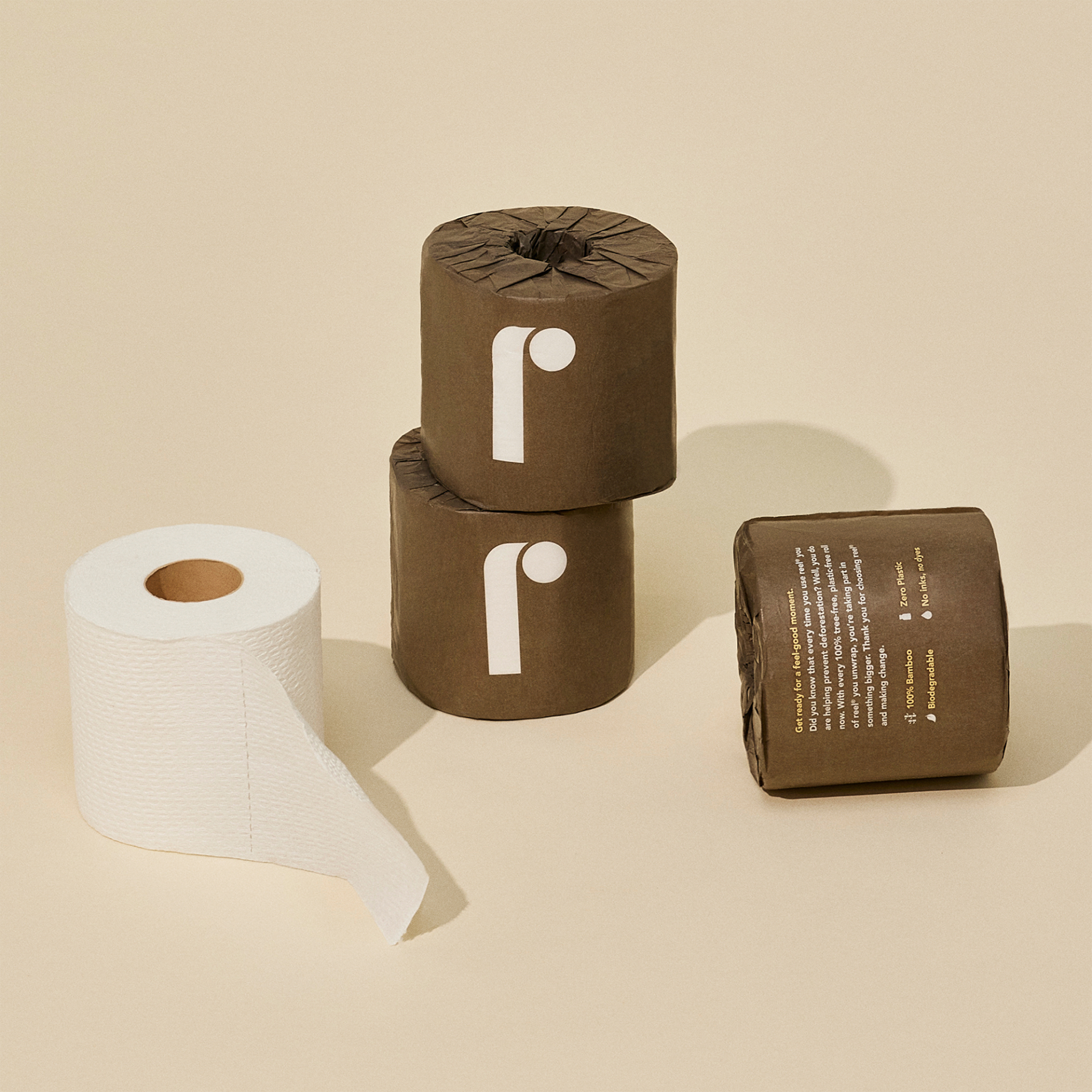 Reel Bamboo Toilet Paper: Tree-free and planet-friendly, one roll is shown out of packaging and thee rolls are shown in brown paper packaging 