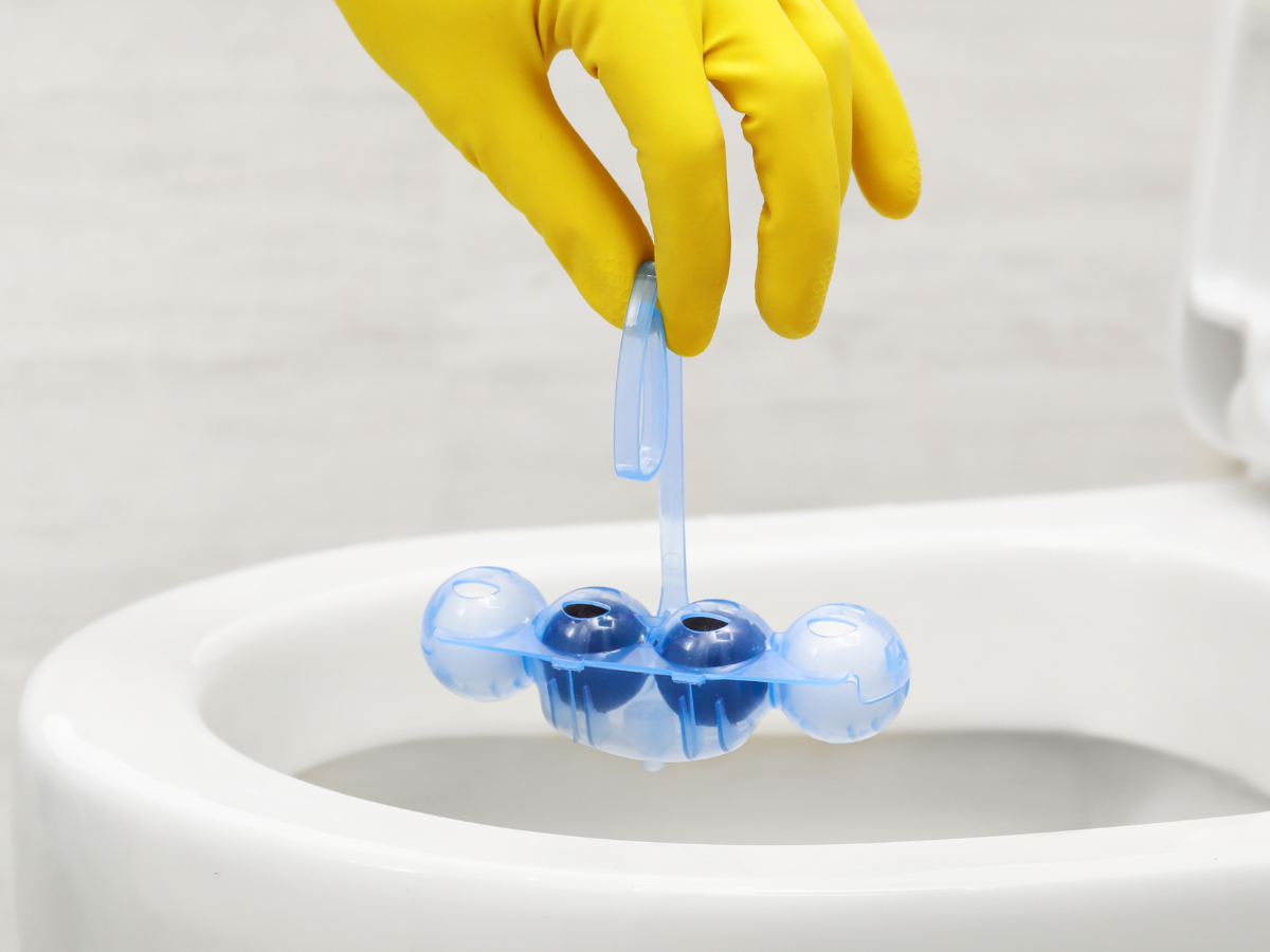 A nontoxic toilet bowl cleaner held by a gloved hand.