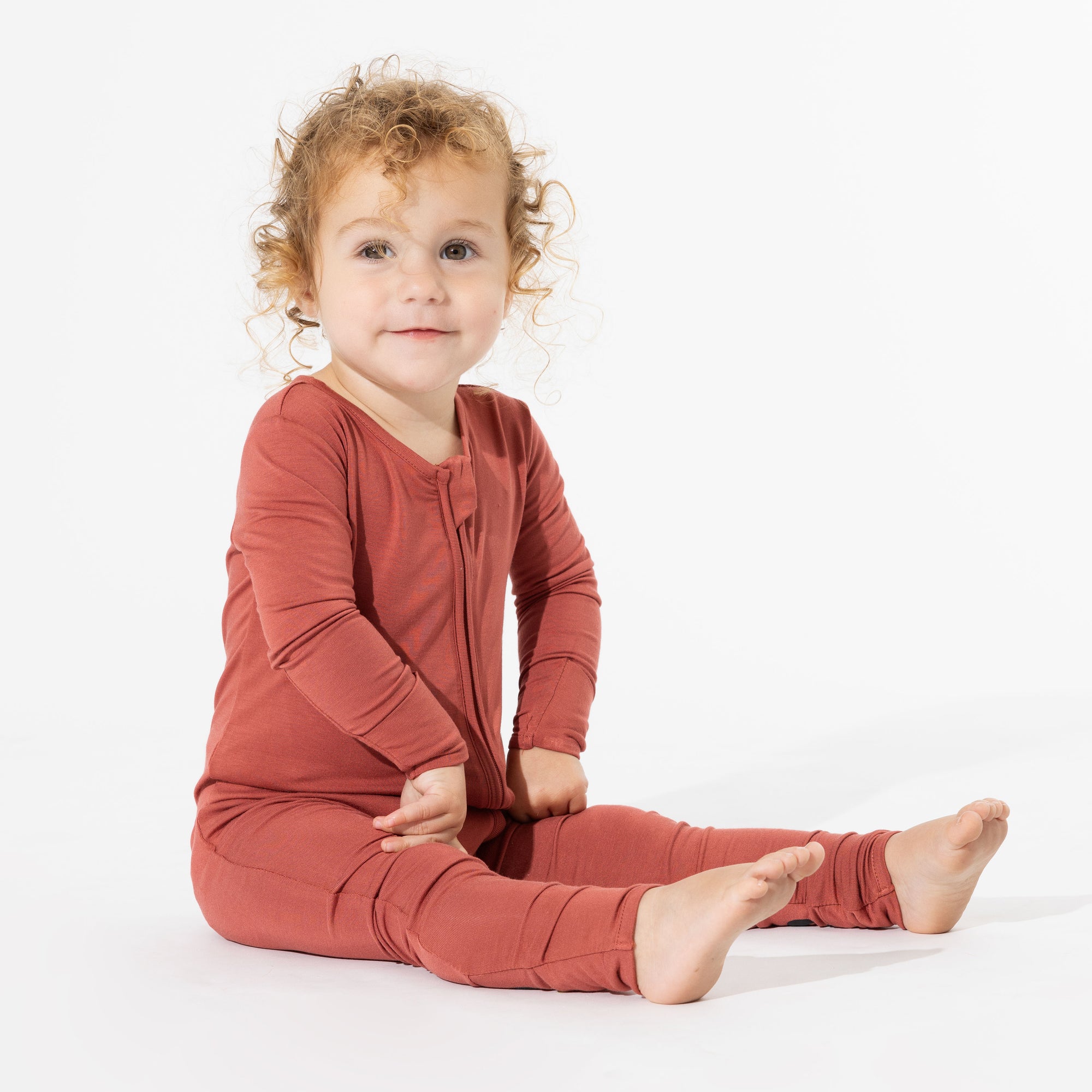 A baby stays cozy in the Terracotta Bamboo Convertible Footie from Bellabu Bear, enjoying the softness and breathable comfort of eco-friendly bamboo fabric.