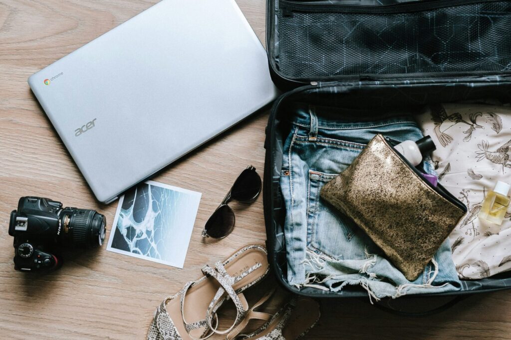 Sustainable Luggage packed with a variety of items including clothing, toiletries, and a makeup bag