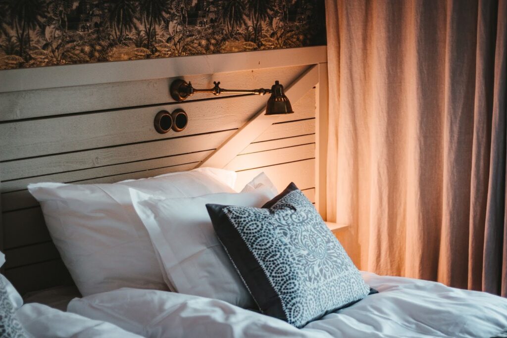 Three pillows on top of a white comforter on a bed 