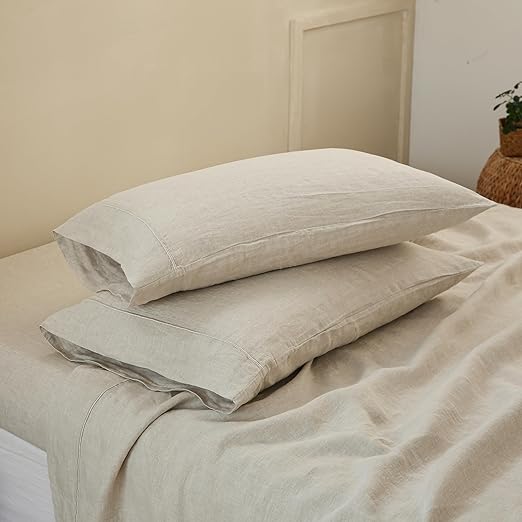 Two pillows on top of a bed covered in King Linens linen pillowcases