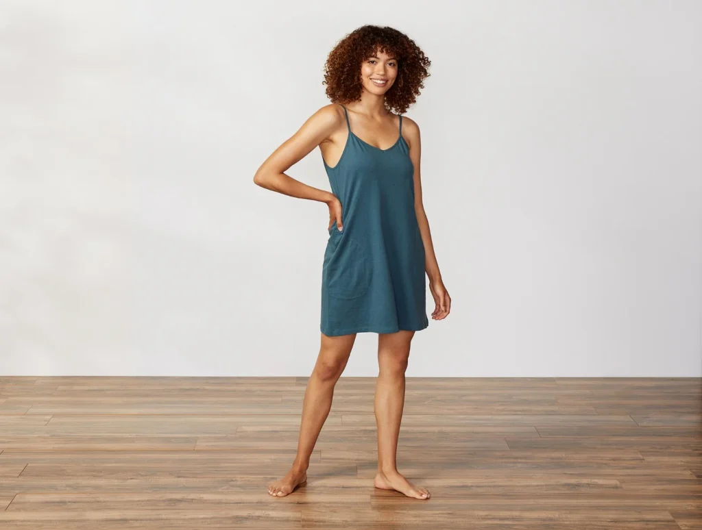 A woman wearing a dark blue-green organic chemise from Coyuchi