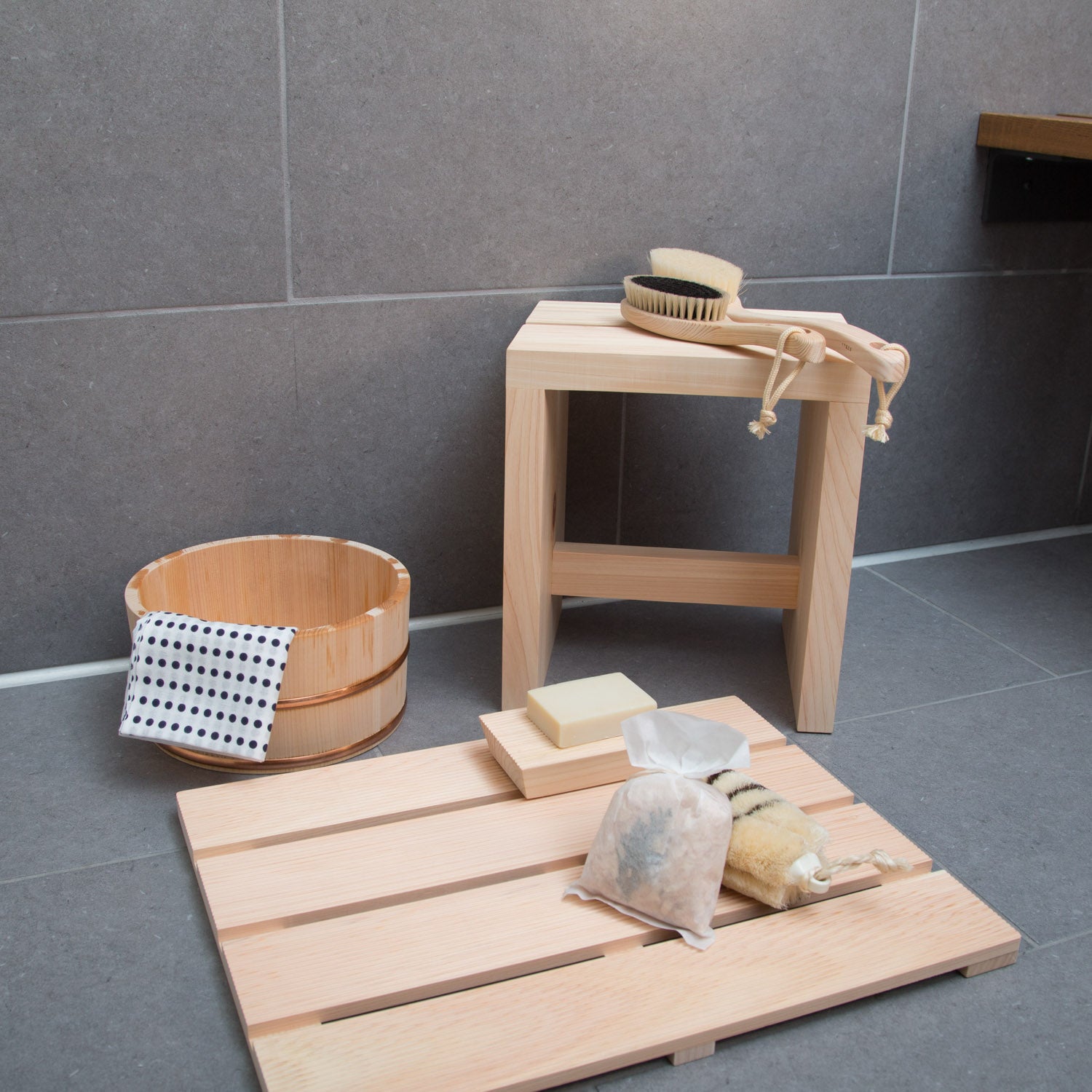 Hinoki wooden bath mat in a tiled bathroom with shower accessories