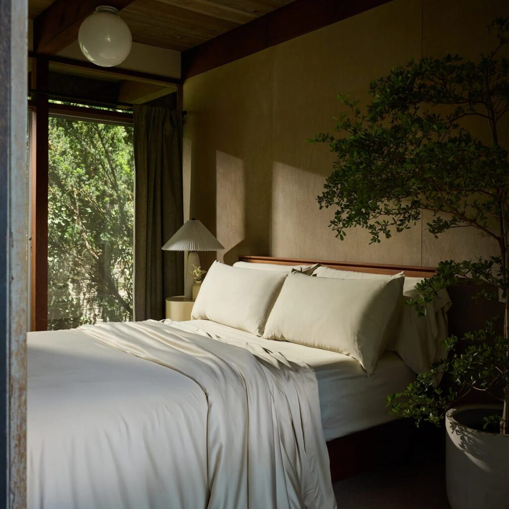 A bed covered in off-white bamboo sheets from Cozy Earth