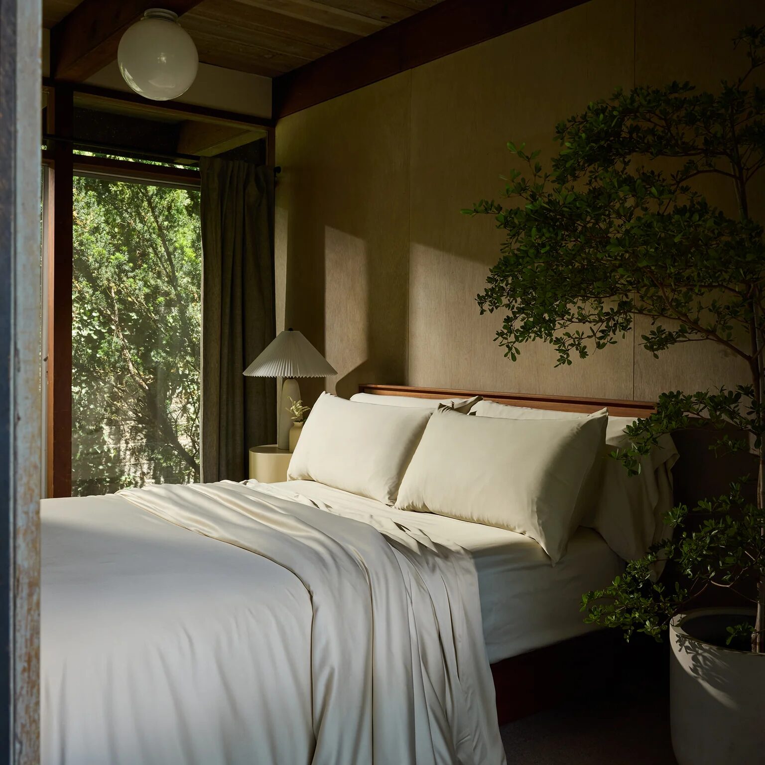 A bed covered in off-white bamboo sheets from Cozy Earth