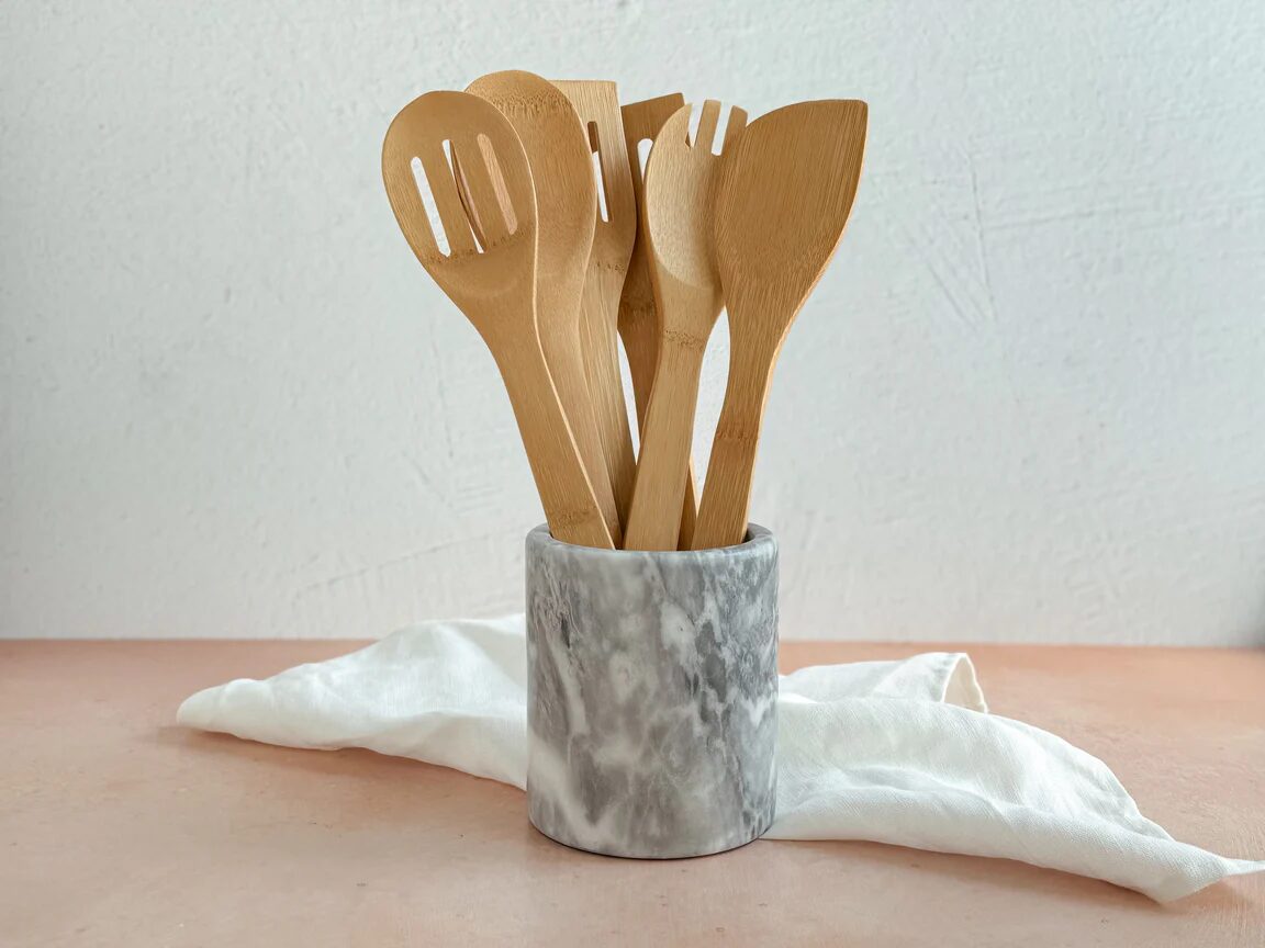 Eco-friendly non-toxic bamboo kitchen utensils in a marble holder, perfect for safe, sustainable cooking.