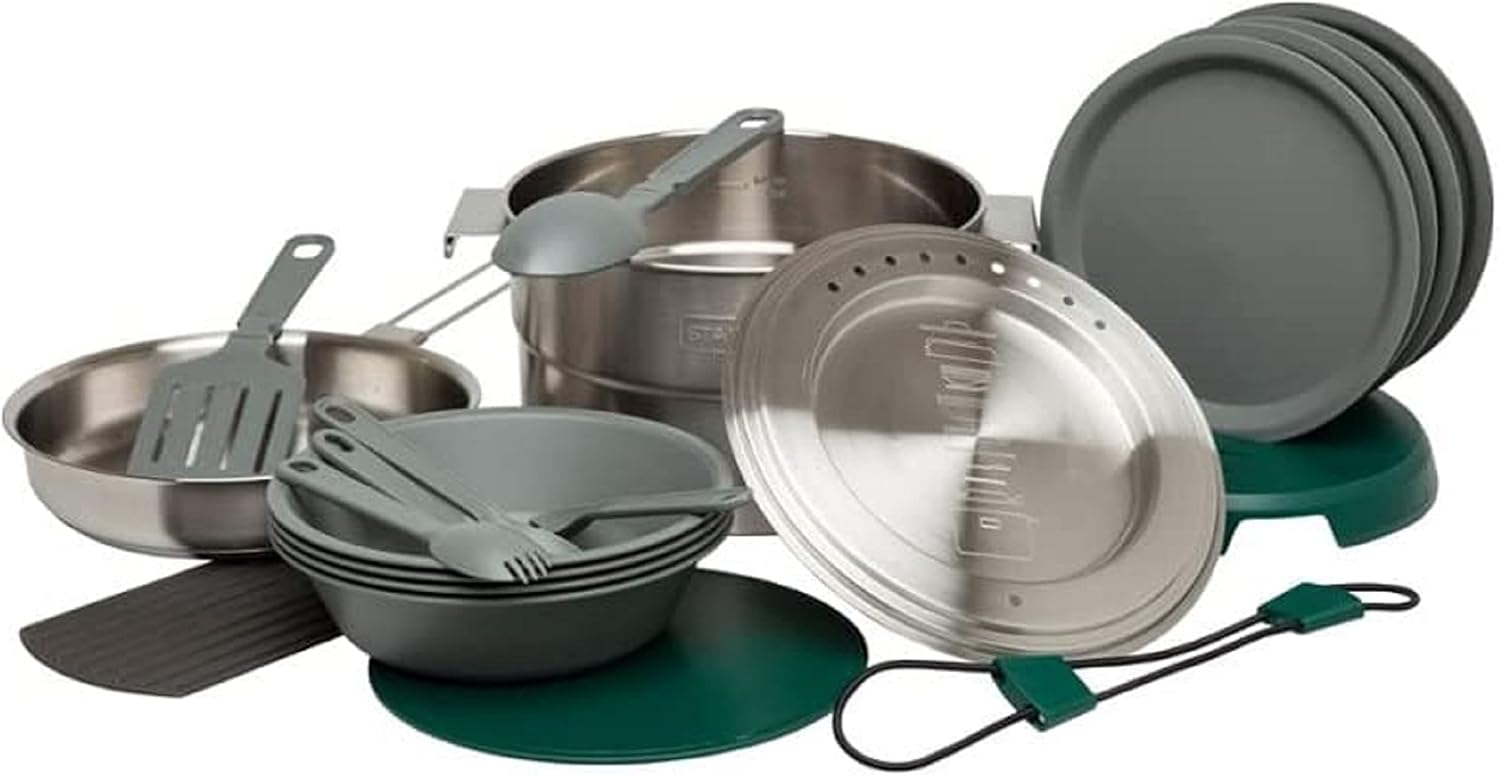 ALT Text: Stanley stainless steel camping cookware set with plates, bowls, utensils, and vented lids for outdoor cooking.