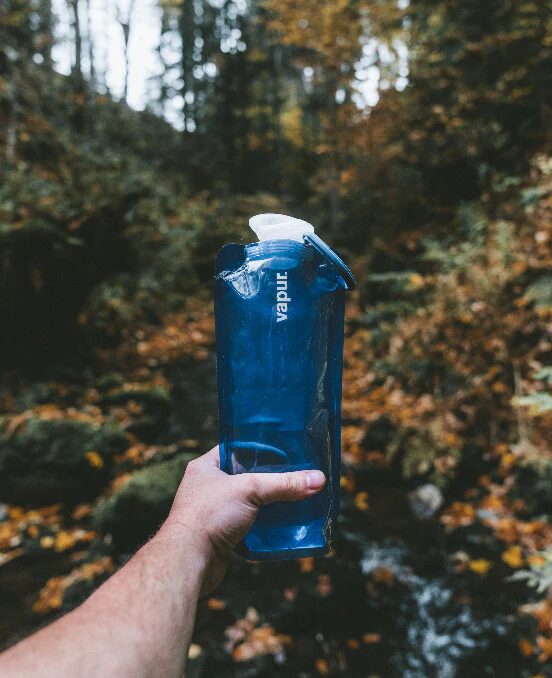 A hiker keeping hydrated with a Vapur Anti-Bottle, a sustainable water bottle made in the USA.