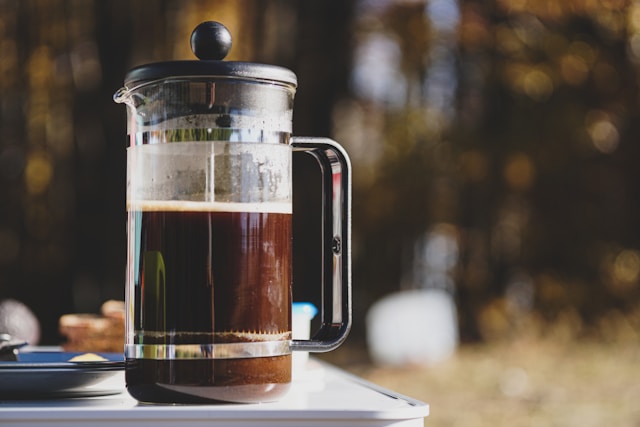 A close-up of a French press coffee maker on a table.